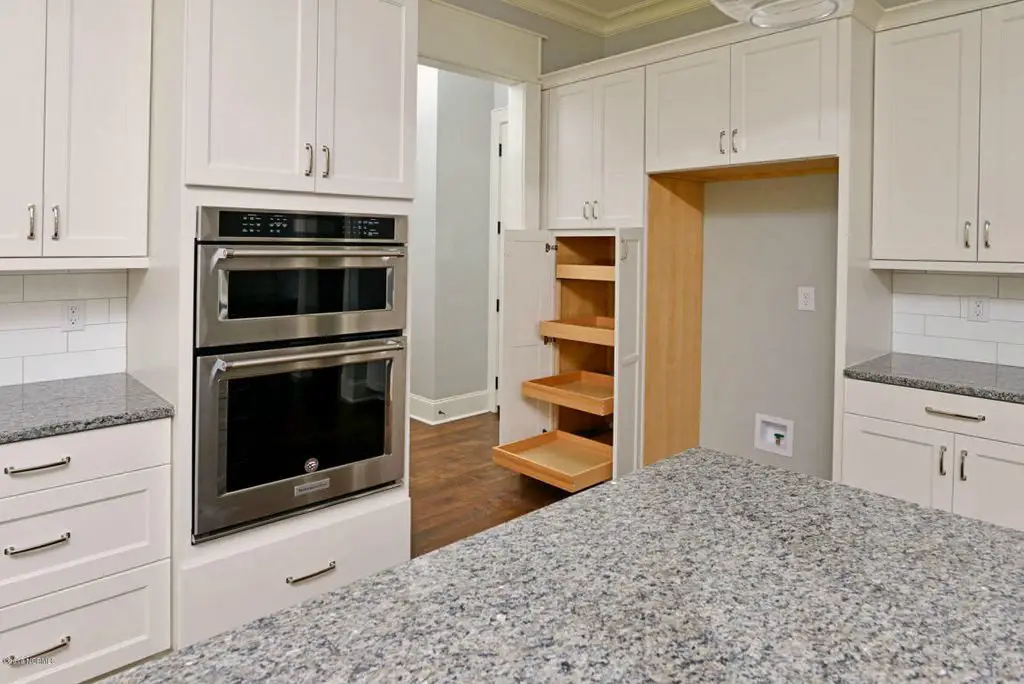 Off White kitchen with granite counters and built-in pantry with pull out shelves