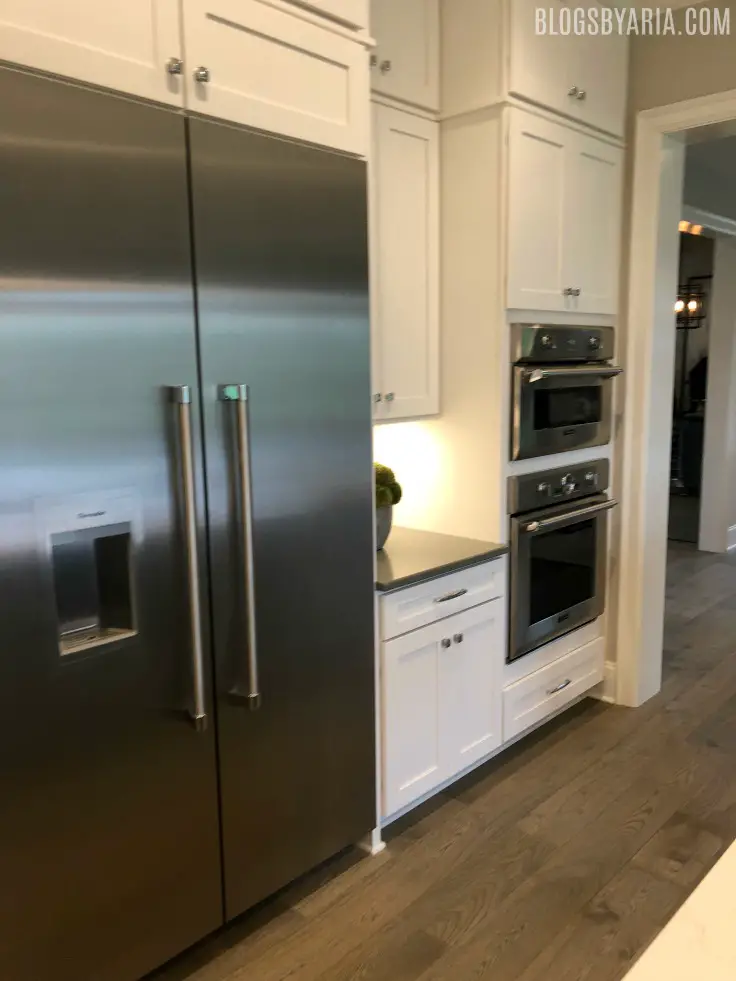 white kitchen wall fridge with double ovens and fridge
