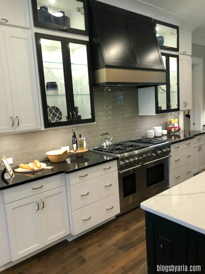 two toned kitchen with white cabinets and black range hood