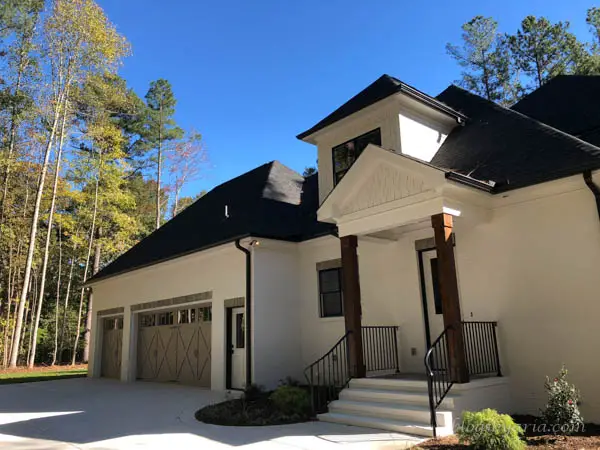 this home is just as beautiful from its side elevation featuring a side door and three car garage