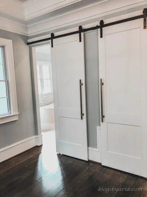 barn doors lead from the master bedroom into the his and hers en suite