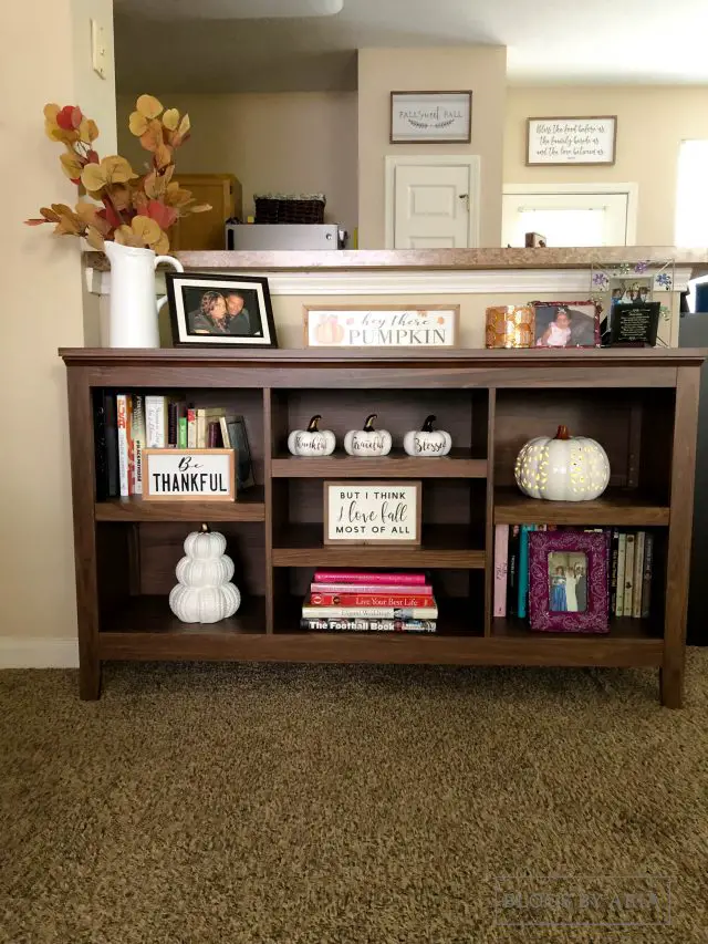 neutral pumpkins decorate this bookshelf for fall