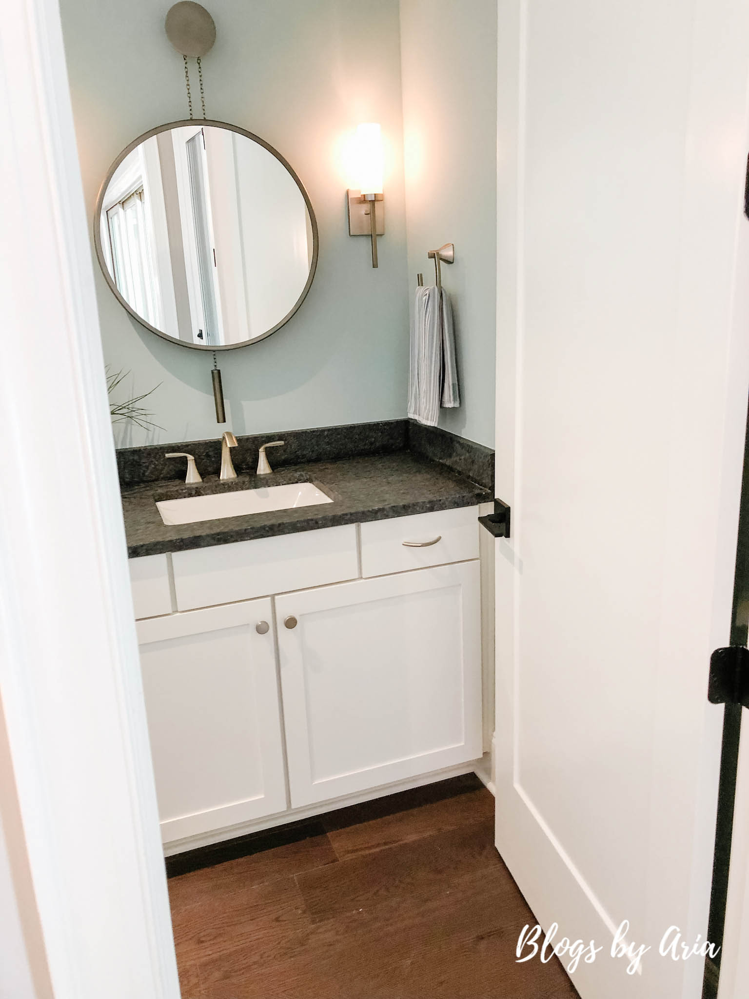 powder bathroom with round mirror