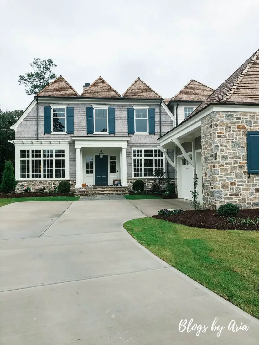 Classic Nantucket Inspired Home featuring gray shingles, flat-board trim, square posts and double-hung windows,