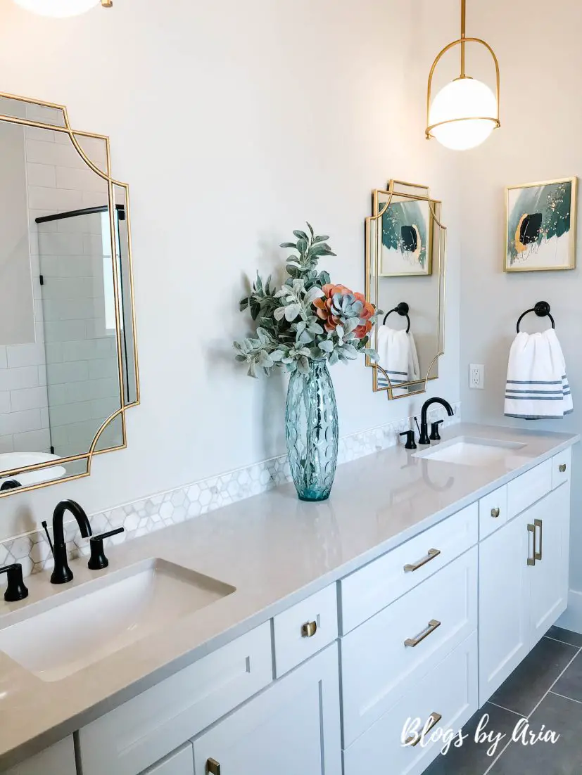 bathroom with gold lighting and black faucets